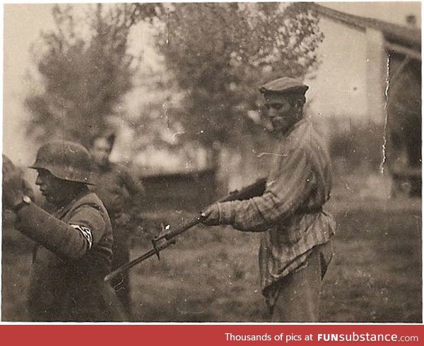 A liberated Jew holds a Nazi guard at gunpoint.