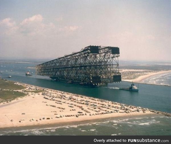 Oil Platforms legs as it heads out to sea, those are cars on the beach