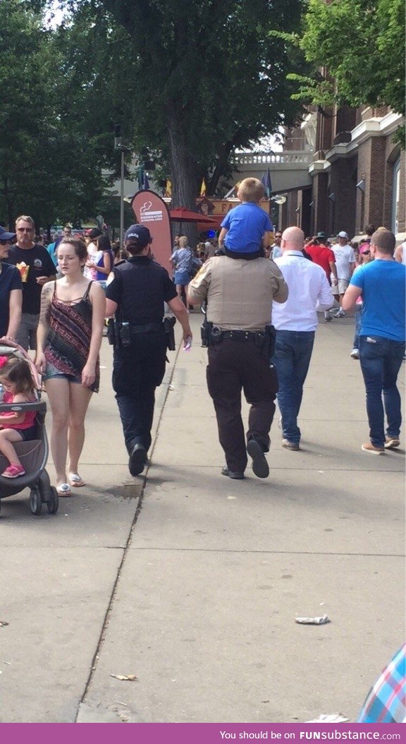 This little guy lost his mom at the state fair, and the police man carried him to find her