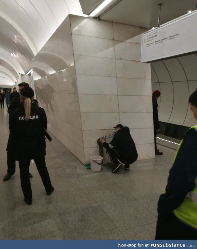 Russian police force Street Artist to clean up the wall