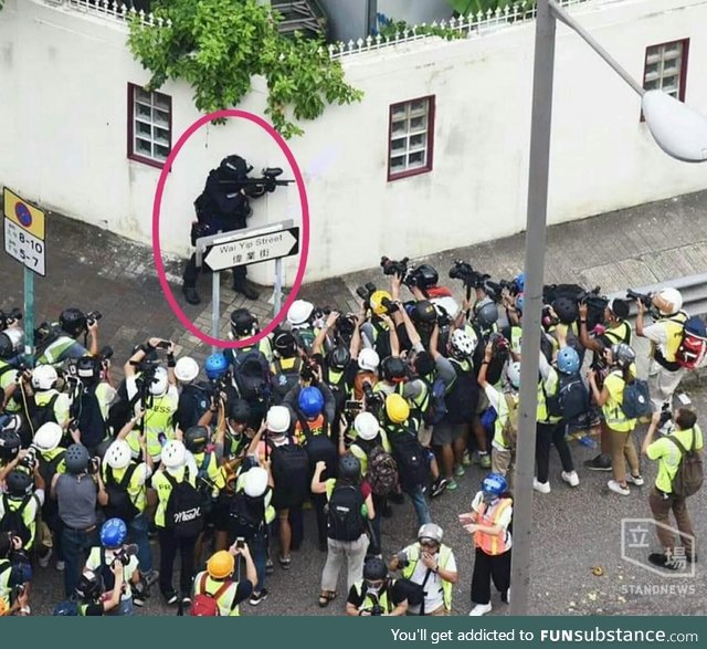 Police Officer (encircled) Surrounded by Photographers in Hong Kong