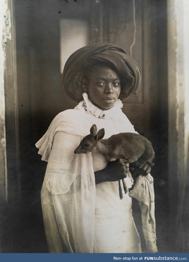 A photogenic Kenyan woman holding her pet deer in Mombassa, 1909