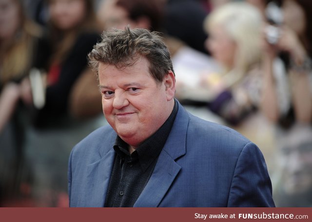 Hagrid without his beard, cleaned up in a suit