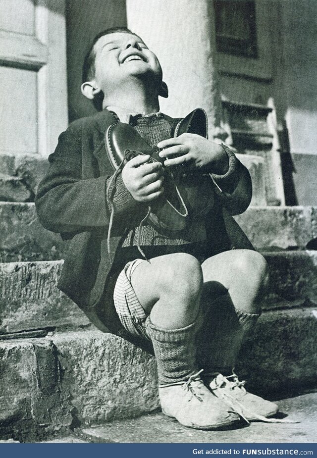 An Austrian boy receiving new shoes during WWII