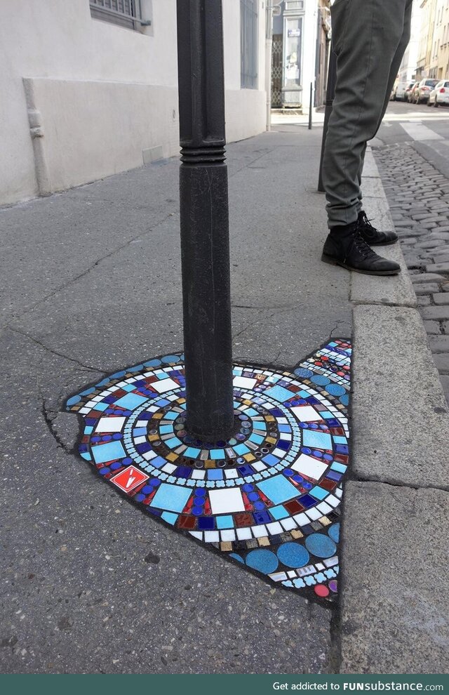 Artist in Lyon, France repairs pavements with colourful mosaics