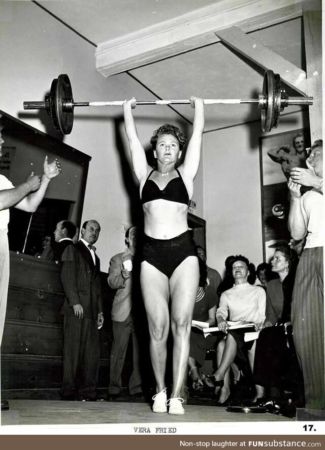 Weightlifting entusiast Vera Fried lifts over 180 pounds overhead to aplause of male gym
