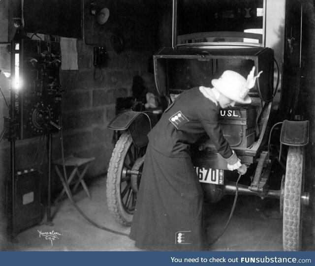 A 1912 photo shows a woman plugging in her electric car