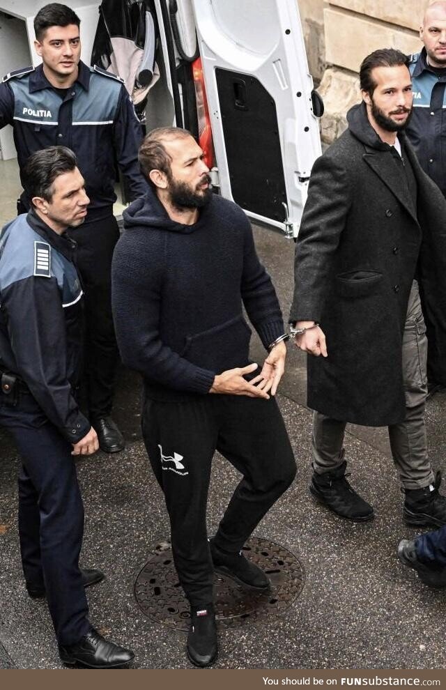 Andrew Tate and his brother Tristan leaving the police van handcuffed together
