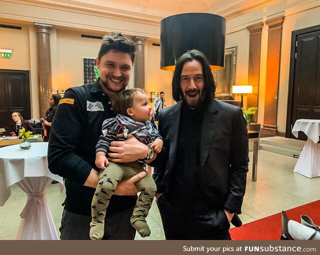 One happy Fan, the one and only Keanu Reeves and one confused baby
