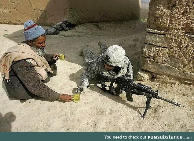 An Afghan citizen offers tea to an American soldier