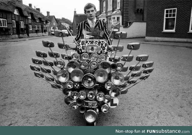 Bryn Owen aged 17 with his Vespa scooter, which has 34 mirrors and 81 lights on the front