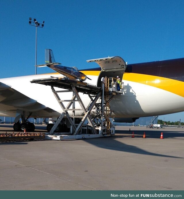 A little plane being loaded into a big plane