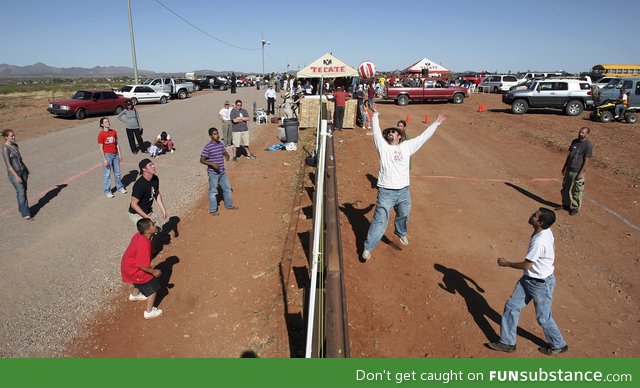 Americans and mexicans playing volleyball over the border in arizona