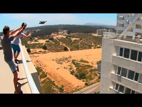 Insane man flies through a narrow gap between two buildings