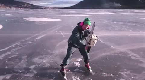 Guy uses his chainsaw to move around a frozen lake