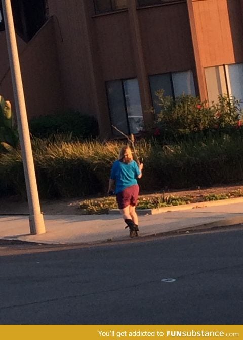 Just a lady walking her bird on a stick