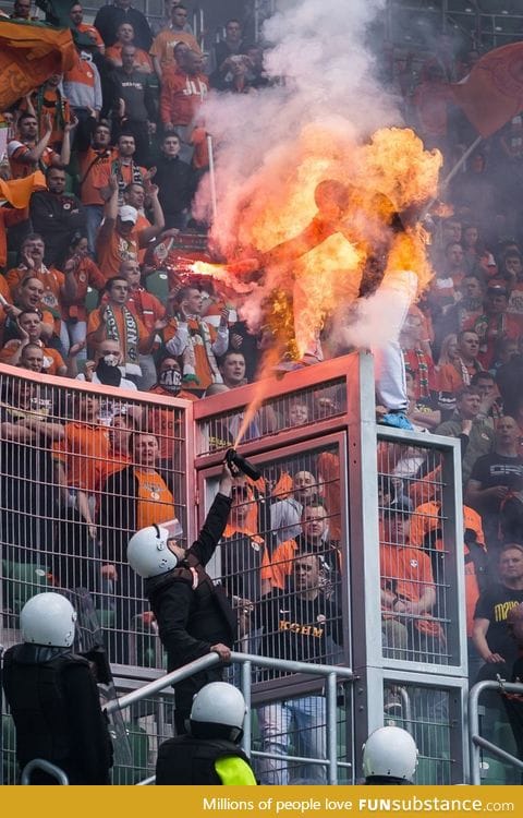 A Soccer fan, armed with a flare, was sprayed by police to prevent him from climbing over