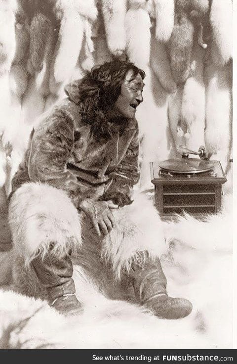 An Eskimo man enjoying some music on a record player in 1922