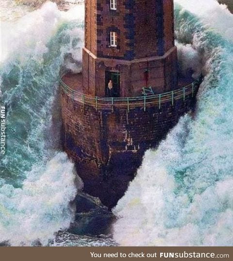 A lighthouse worker surrounded by a storm surge