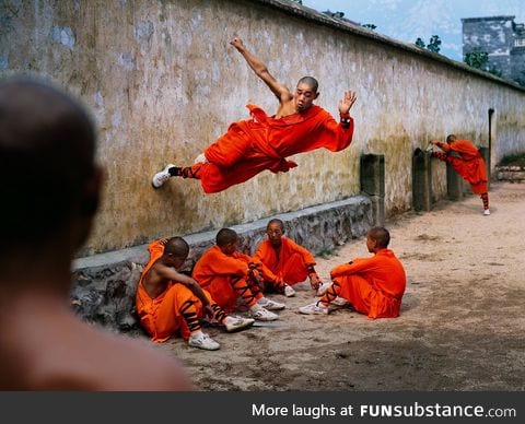 Monk running along wall, Hunan Province, China