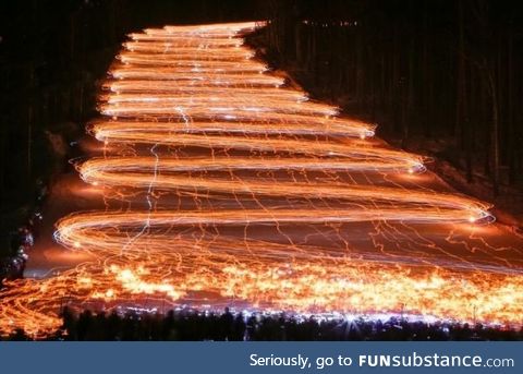 Long exposure of hundreds of skiers holding flashlights