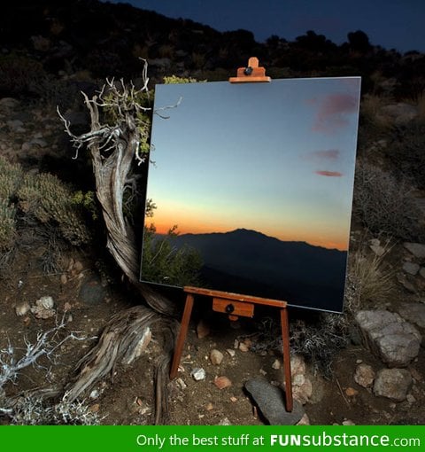 Photograph of a mirror on an easel in the desert that looks like a painting