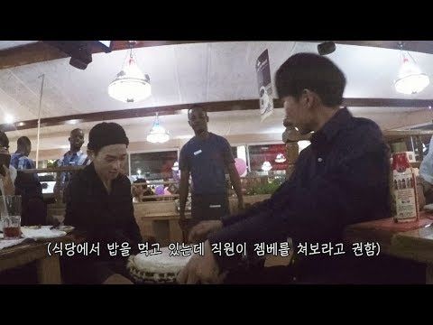 Restaurant staff in South Africa give a group of Korean guests a jembe to try and then...