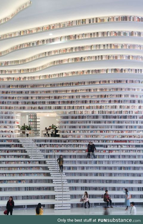 Tianjin Binhai Library in China incorporates bookshelves into the stairs and seating to