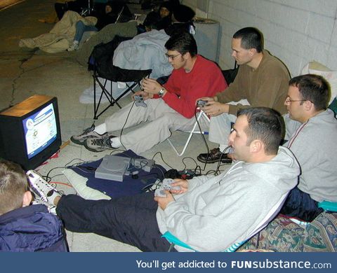 A group of guys outside Best Buy playing PS1 while waiting in line for the greatly