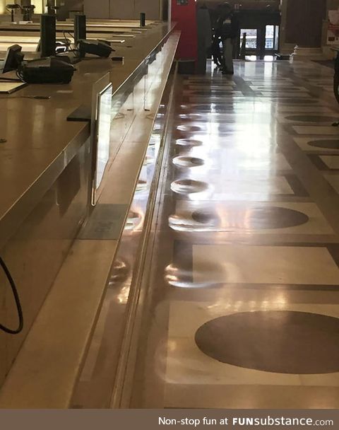 The marble floor of this bank has been worn away from decades of people standing in the