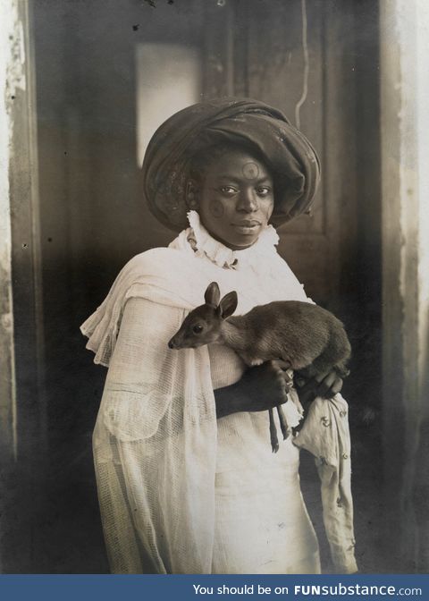 A photogenic Kenyan woman holding her pet deer in Mombassa, 1909