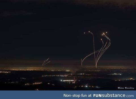 Rockets shot from Gaza (left) are met with intercepting rockets from the Iron Dome