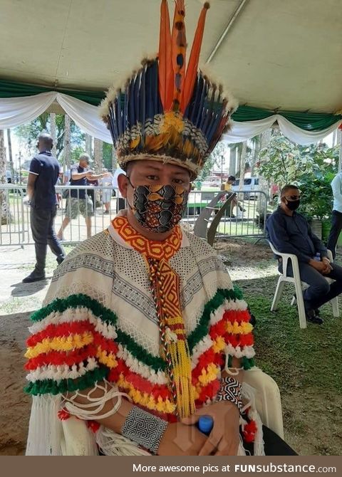 Indigenous man with face mask matching his beautiful traditional attire