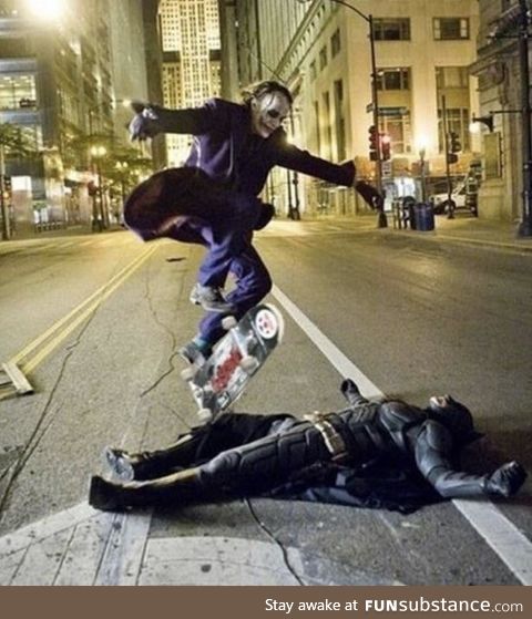 Heath ledger as the joker skateboarding over Christian bale as Batman. During a break