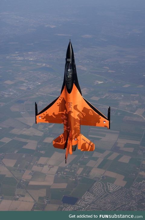 A Dutch F-16 Falcon above a typical Dutch landscape