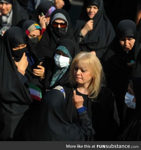 Iranian woman protesting mandatory hijab in a pro-regime rally