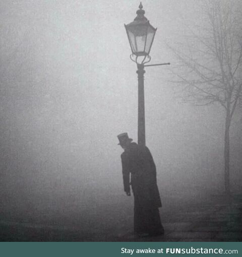 A drunk man in a top hat clings to a lamp-post in London, 1934 Photo is by Bill Brandt