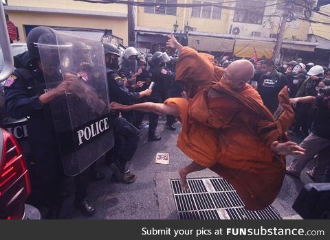 Thailand monk kicking police during a protest. November 2022