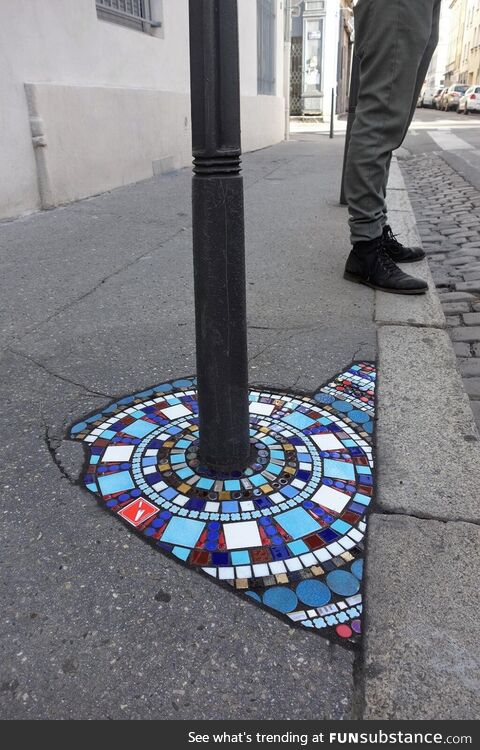 Artist in Lyon, France repairs pavements with colourful mosaics