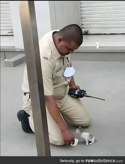 Indian police officer feeding a smol cat
