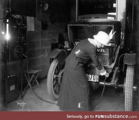 A 1912 photo shows a woman plugging in her electric car