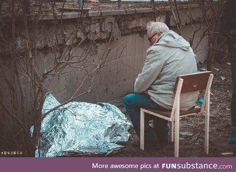 Ukrainian grandfather sits next to the murdered nine-year-old granddaughter