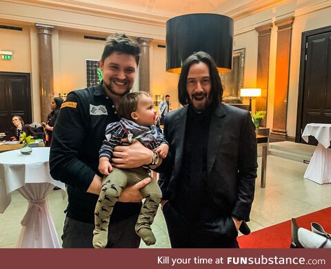 One happy Fan, the one and only Keanu Reeves and one confused baby