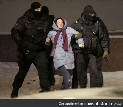 Police officers detain a woman who laid flowers for Alexi Navalny in St. Petersberg