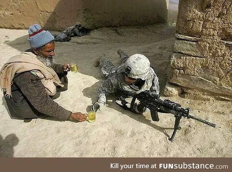 An Afghan citizen offers tea to an American soldier