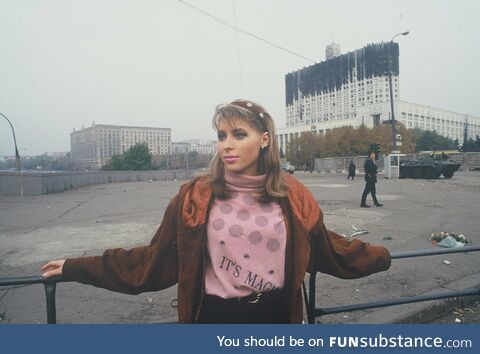 Russian woman, with the background of the burnt out Parliament building (the aftermath of